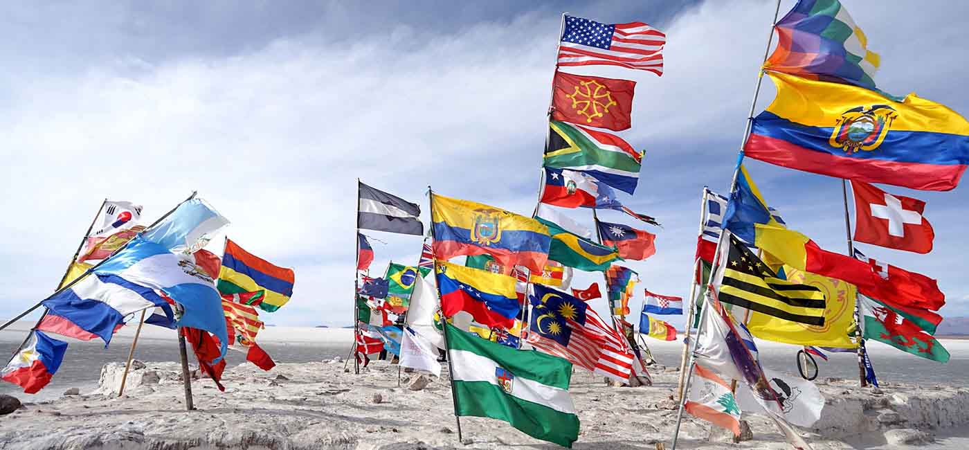 Multiple country flags blow in the windy desert
